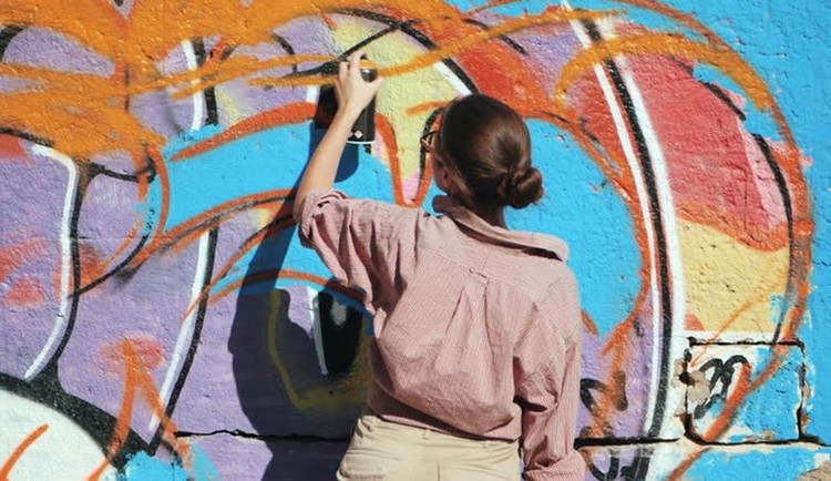 девочка рисует на стене